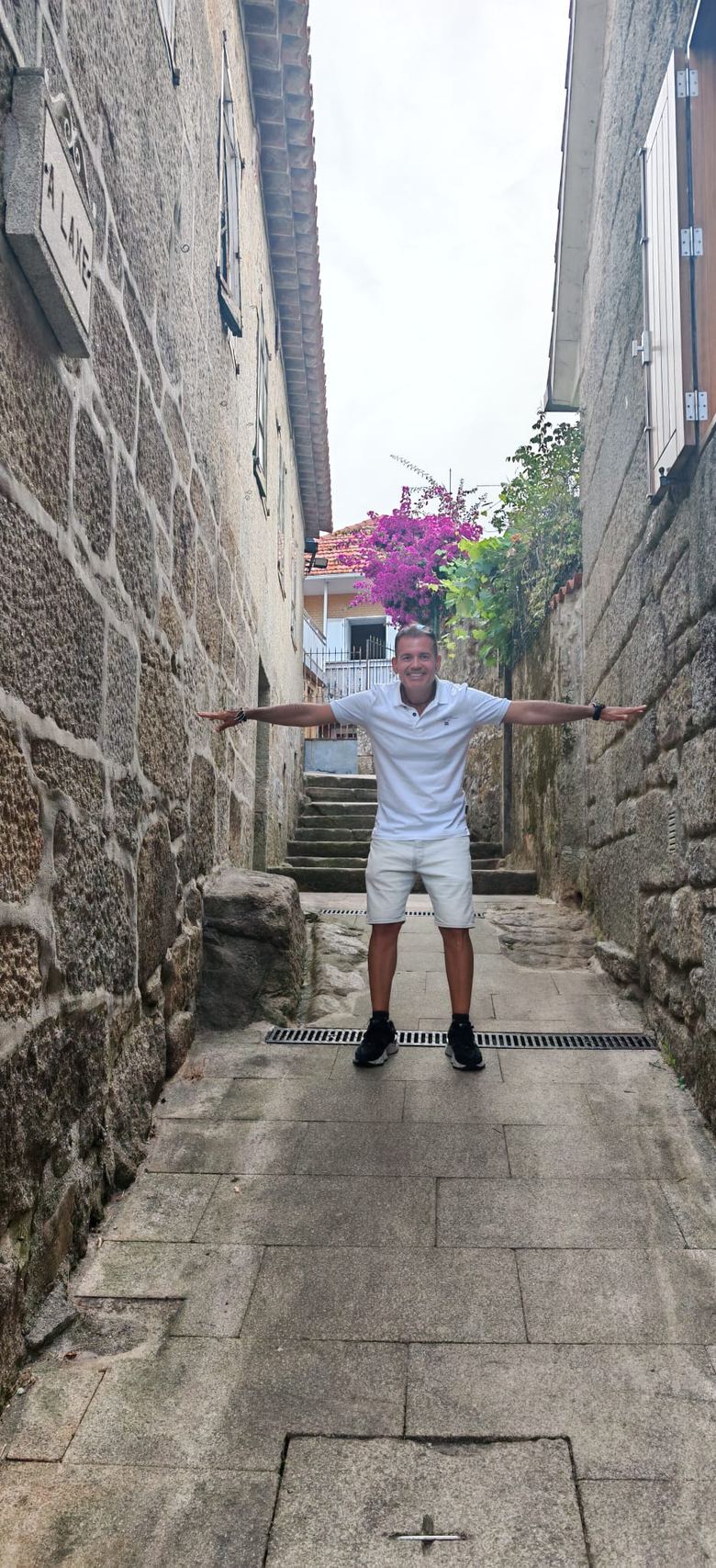 Fundador de SportBeat con los brazos extendidos entre dos muros de piedra